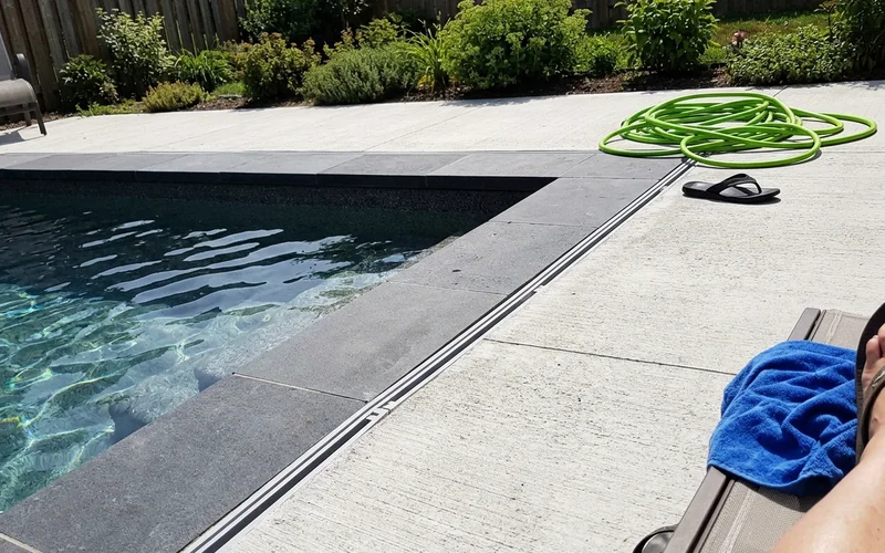 Completed pool showing coping, decking, and drainage along the edge