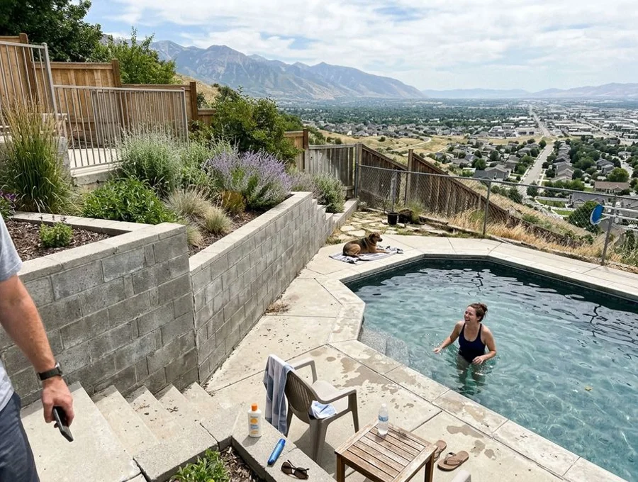 Hillside pool with retaining wall and terraced decking on a sloped Draper lot